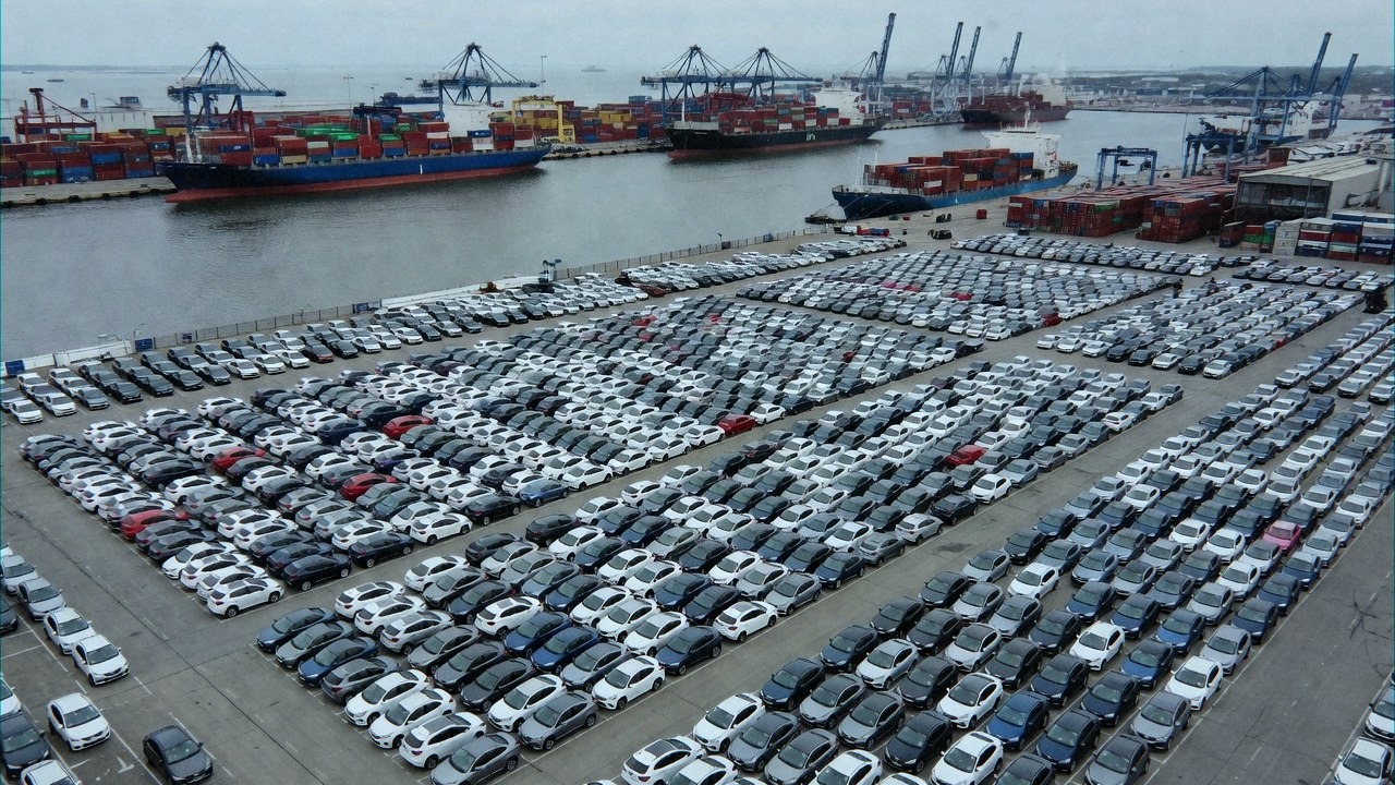European port terminal with a long line of newly imported Chinese hybrid cars